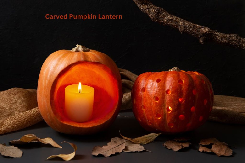 Two carved pumpkin lanterns, one with a candle inside, surrounded by autumn leaves on a dark background.